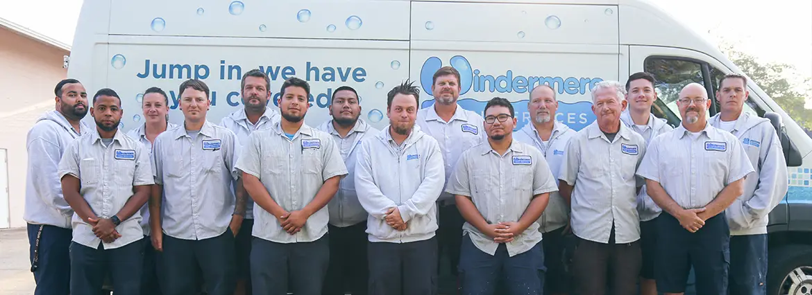The uniformed Windermere Pool Services team standing in front of a branded company van